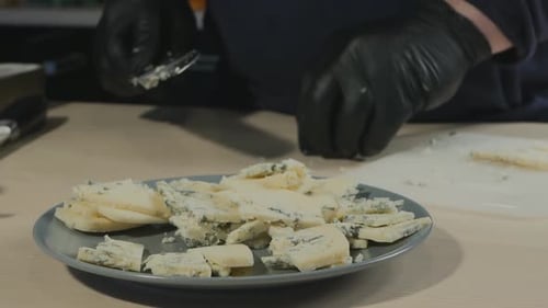 El chef pastelero con un cuchillo grande corta el queso con el molde Dorblu en un bol
