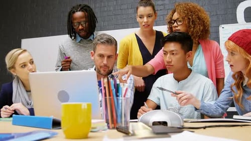 Diverse Team Collaborating on Laptop in Modern Office