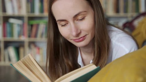 Close Up Woman Lying on a Comfortable Couch and Reading an Exciting Book