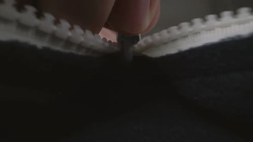 Extreme Close Up Zipper with Hand Unzipping the Sweater Jacket Zipper