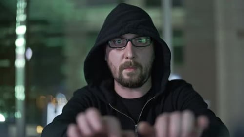 Hooded Man Typing on Computer