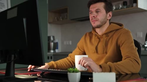L'homme travaille à distance au bureau à domicile à l'aide d'un ordinateur
