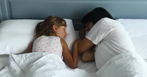 Child and Adult Sleeping, Holding Hands in Bed