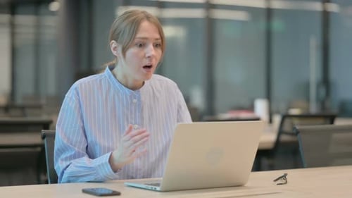 Astonished Woman Gesturing at Laptop in Modern Office