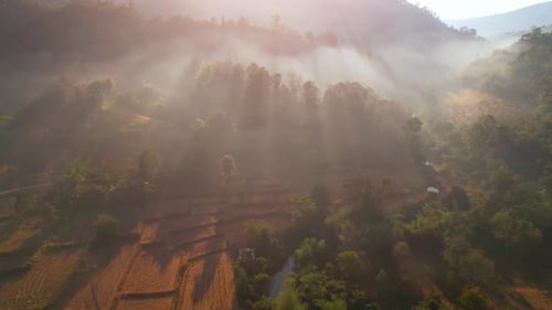 Aerial view from a drone over misty landscape on farmland. mountains in the background. 4K