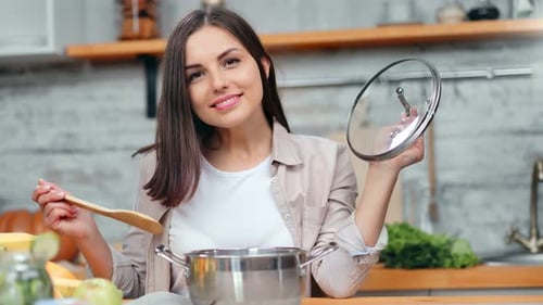 Young Woman Cooking at Home in Kitchen
