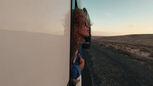 Woman Enjoys Desert Road Trip from Bus Window