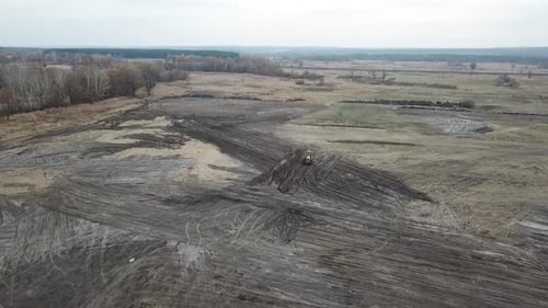 Atemberaubende Aussicht auf ein riesiges Feld und einen Bagger, der im Dreck fährt