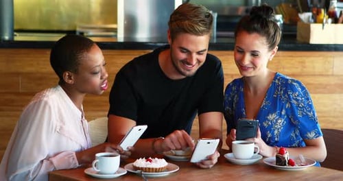 Friends Enjoying Coffee, Smartphones in Modern Cafe