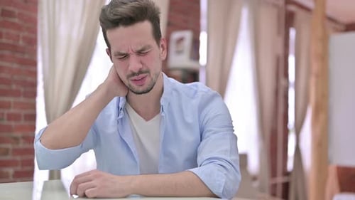 Young Adult Massaging Sore Neck Indoors