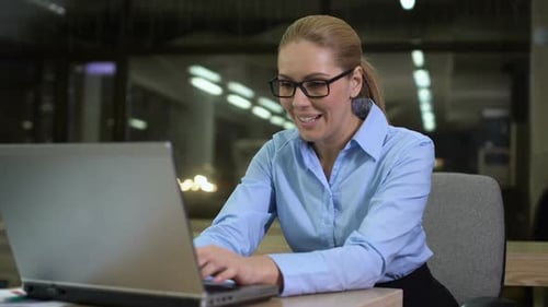 Happy Businesswoman Rejoicing Successful Startup, Sitting in Office at Night