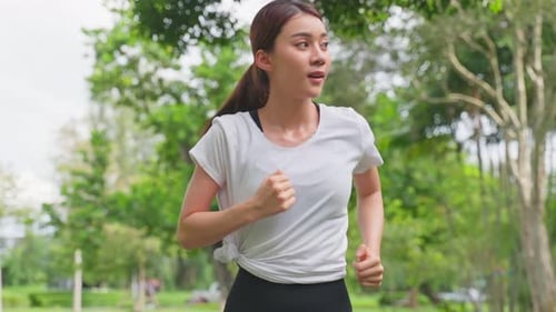 Asian young beautiful sport woman exercise by running on street in public park for health in garden.