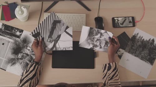 Top View of Female Retoucher Looking at Black and White Photos