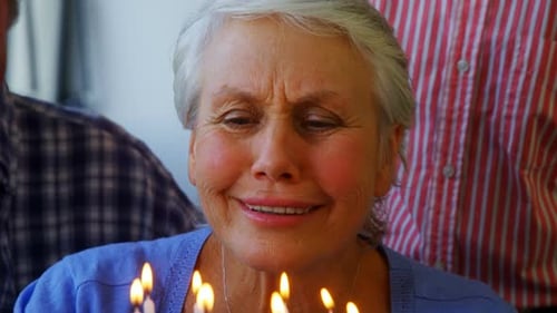 Senior Woman Celebrates Birthday with Lit Candles