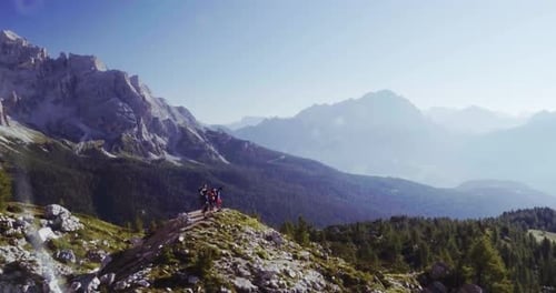 Aerial Flight Above People Hiking Along Trail Path in Sunny Day