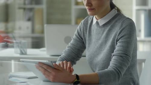 Businesswoman Working on Digital Tablet at Office Desk