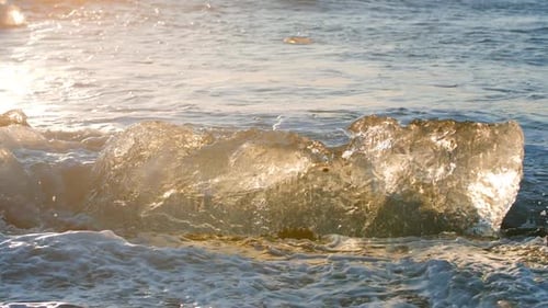 Waves Crashing Around Glacial Ice at Sunrise