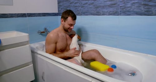 Man Giving Jack Russell Dog Bath in Tub