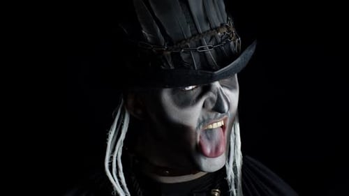 Frightening Man in Skeleton Halloween Costume Appearing From Darkness When Light Falls on Him