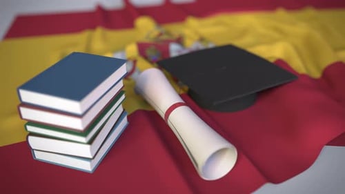 Casquette de fin d'études et diplôme sur le drapeau espagnol