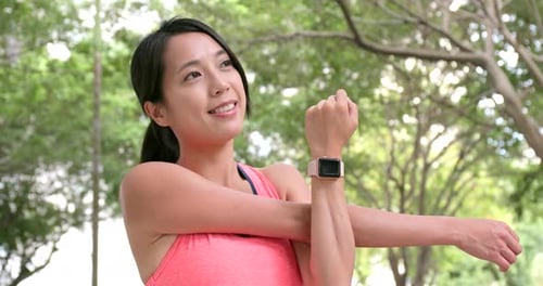 Woman Stretching Arm Outdoors in Green Park