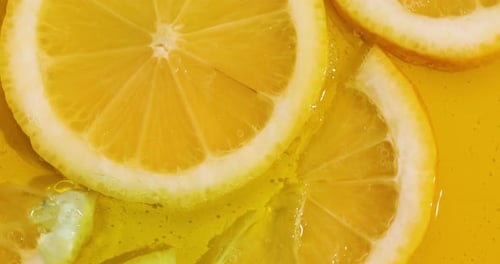 Top view rotation of fresh slice of lemons juice and gel serum pours