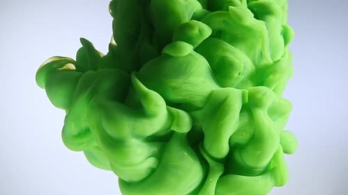 Green Color Paint Drops in Water Against White Background