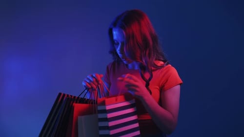 Woman Holding Shopping Bags in a Studio Setting
