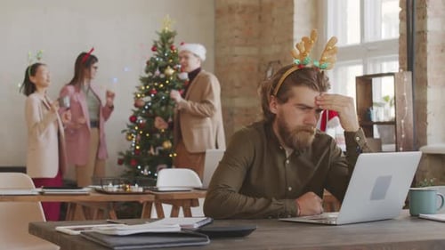 Overworked Businessman Working in Office on Christmas