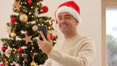 Man in Santa Hat Video Chatting at Christmas