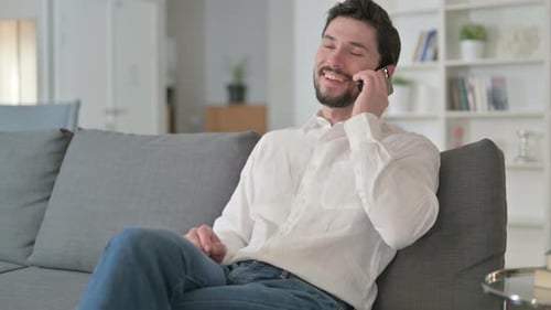 Man Talking on Smartphone on the Couch