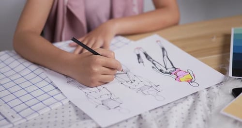 Close up hand of Woman fashion designer draws a sketch of women's clothing