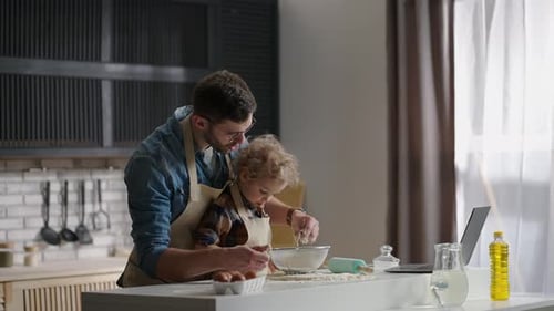 Father and Child Baking Together in Sunny Kitchen