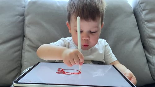 Young Child Drawing With Tablet on the Couch