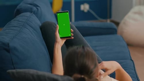 Woman Relaxing on Couch Using Phone with Green Screen