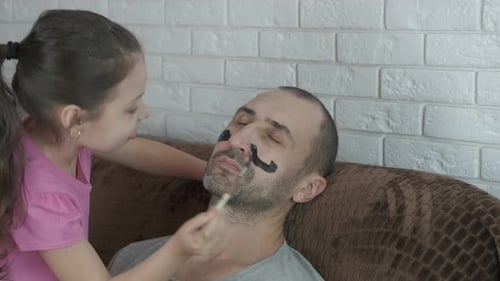 Playful Girl Drawing on Dad's Face with Makeup