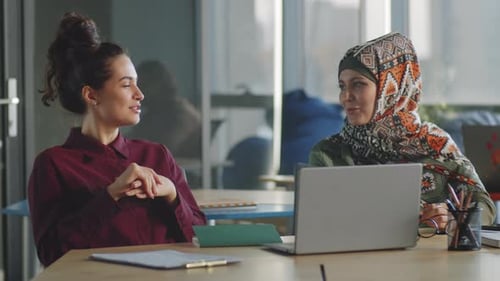 Women Collaborating on a Laptop in Modern Office