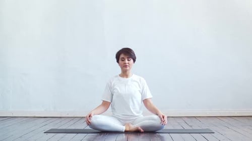 Woman Meditating Indoors in Lotus Position
