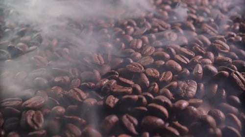 Ароматные кофейные зерна в процессе обжарки с присутствием небольшого количества дыма