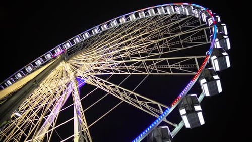 Ferris Wheel at Amusement Park, Colorful Illuminated Construction Moving Slowly