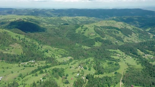 Aerial Drone View of a Village on a Green Forested Mountainside.