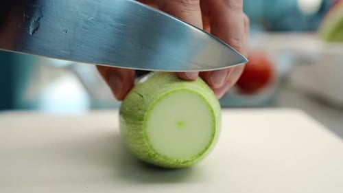 Close-up: The chef cuts the zucchini finely with a knife