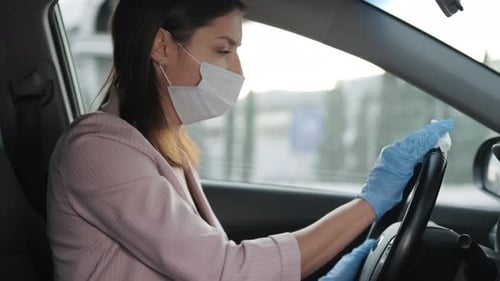 Woman with Mask Cleans Car Steering Wheel