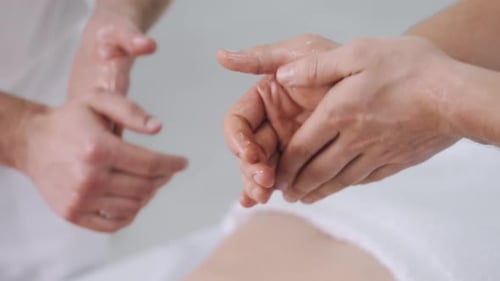 Nahaufnahme Masseure reiben Hände mit Massageöl