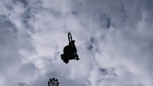Bike Stunt Silhouette Against Cloudy Sky