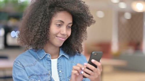 Young Woman Using Smartphone in Bright Interior