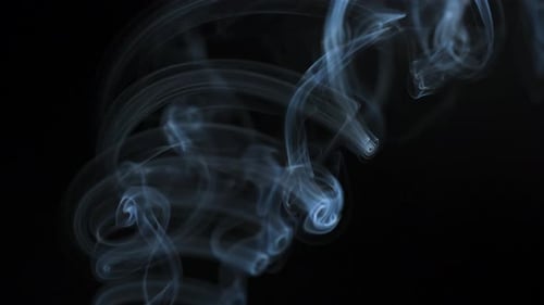 Wispy smoke trails on black background