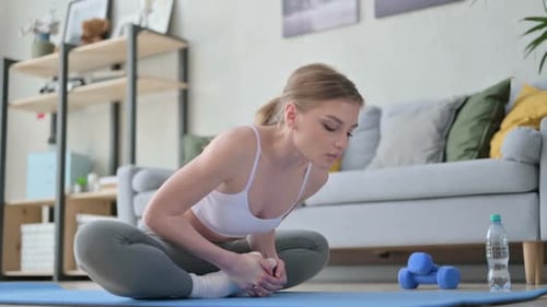 Woman Stretching Legs in Seated Yoga Position at Home