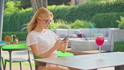 Young Woman Enjoys Talking on the Phone Texting with Someone in a Wonderful Place Sitting in a White