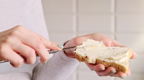 Spreading Cream Cheese on Bread for Breakfast